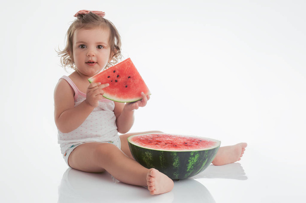 Menina bebê comendo fatia de melancia isolada no fundo branco
 - Foto, Imagem