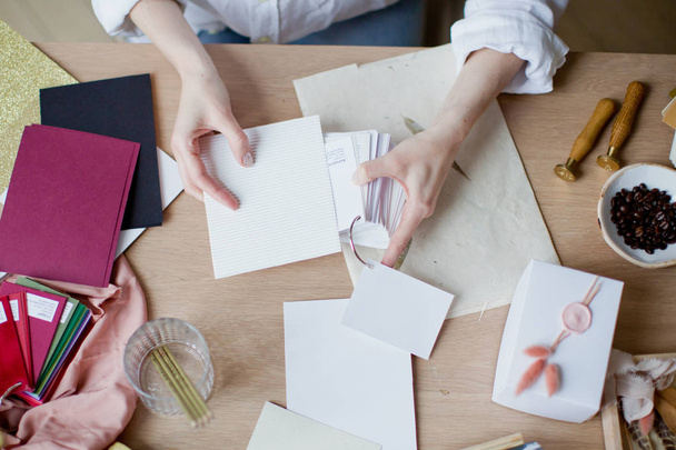 Mujer en el lugar de trabajo eligiendo cartas de papel de colores
 - Foto, Imagen