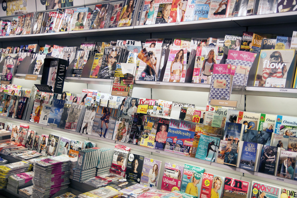 Διαφορετικοί τύποι περιοδικών που εμφανίζονται σε μια σχάρα τοίχου σε ένα βιβλιοπωλείο - Φωτογραφία, εικόνα