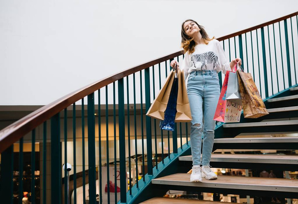 shopping, happiness and people concept - smiling stylish teenage girl with shopping bags. shopping concept - Foto, imagen