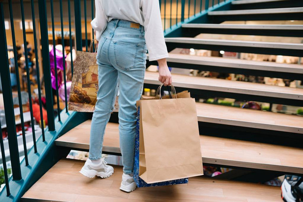 Shopping time, closeup of teenage girl legs with shopping bags at shopping mall - 写真・画像