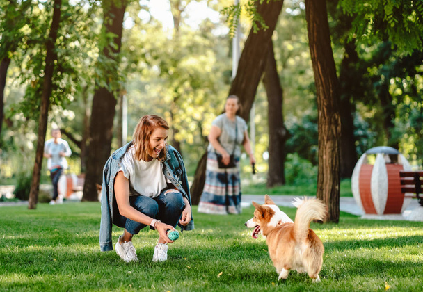 Retrato de mujer con perro Galés Corgi Pembroke en parque de perros - Foto, Imagen