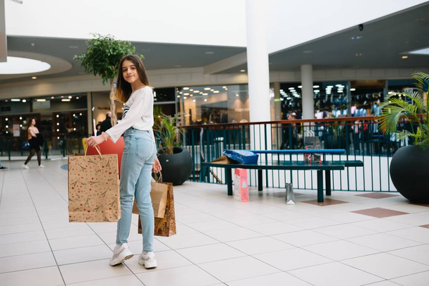 Shopping time, closeup of teenage girl legs with shopping bags at shopping mall - Valokuva, kuva