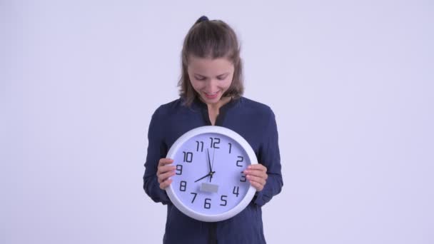 Happy young beautiful businesswoman holding wall clock - Кадры, видео