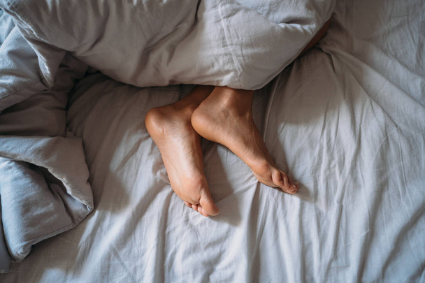 Close-up woman feet alone in white bed - Zdjęcie, obraz