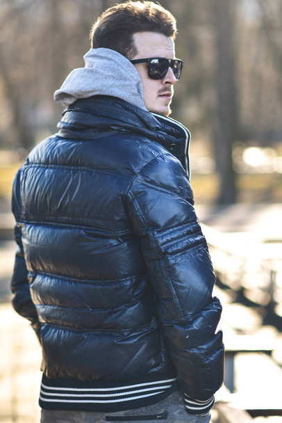 Portrait d'homme séduisant en lunettes de soleil avec des vêtements décontractés marcher dans le parc
 - Photo, image