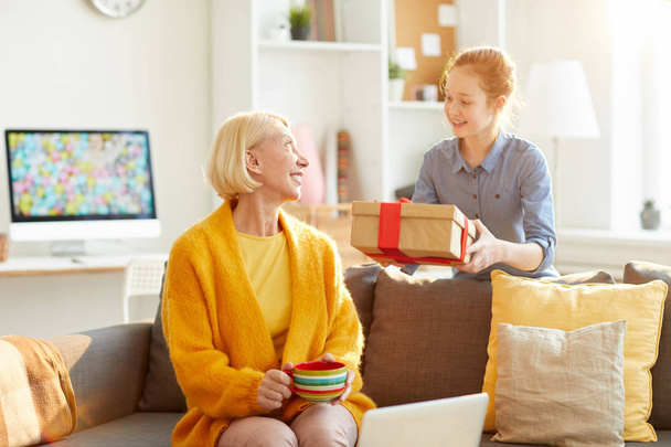 Portrait of happy red haired girl giving present to mom on Birthday or Mothers day, copy space - 写真・画像