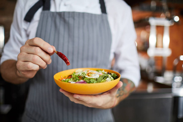 Портрет невідомого шеф-кухаря, який кладе гострий перець чилі у салат, простір для копіювання
 - Фото, зображення