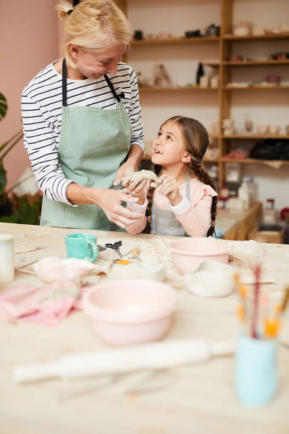 Portret van gelukkige moeder en kind in aardewerk klasse maken handgemaakte keramiek, kopieer ruimte - Foto, afbeelding