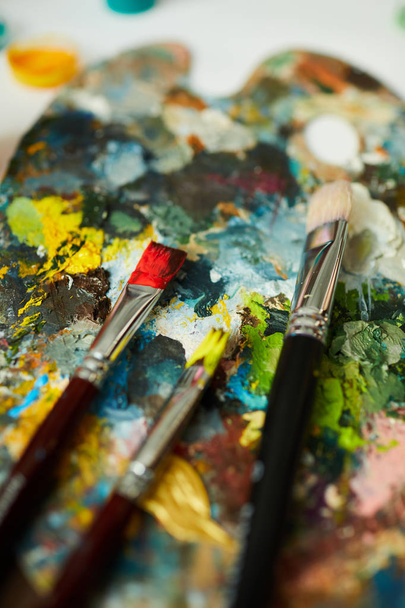 Close up of artists palette with paintbrushes on it, oil painting background - Foto, Imagem