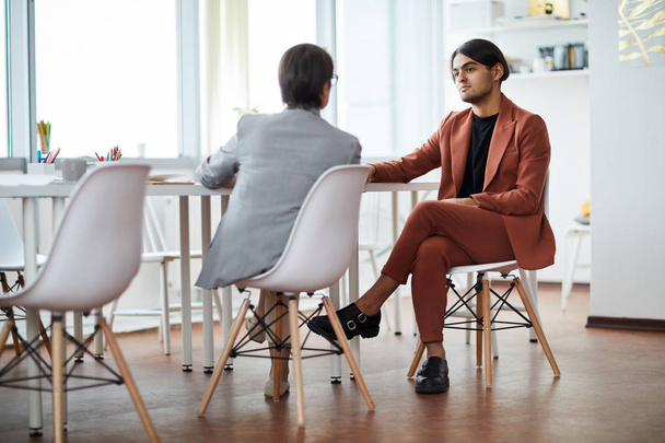 Full length portrait of contemporary Middle-Eastern man listening to HR manager during job interview in office, copy space - Photo, Image