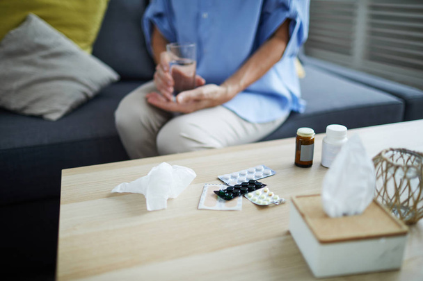 Крупним планом таблетки і різні ліки на столі перед невпізнаваною старшою жінкою, копіювати простір
 - Фото, зображення