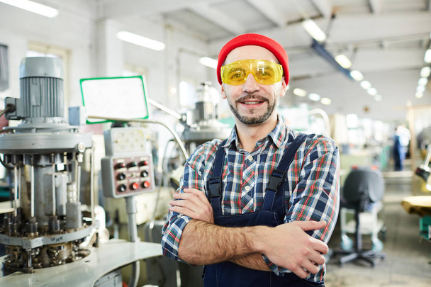 Portrét dospělého vousatého muže, který pracuje v továrně a který se sebevědomě nachází v průmyslové dílně, místo kopírování - Fotografie, Obrázek