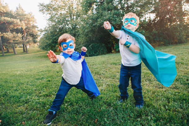 Милые очаровательные дети дошкольного возраста, играющие в супергероев. Два мальчика, дети, веселятся вместе на улице в парке. Мощь, сила и концепция защиты. Счастливое активное детство
 - Фото, изображение