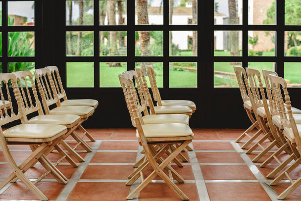 Много пустых белых деревянных стульев, выстроенных в ряд для мероприятия в стиле ретро
. - Фото, изображение