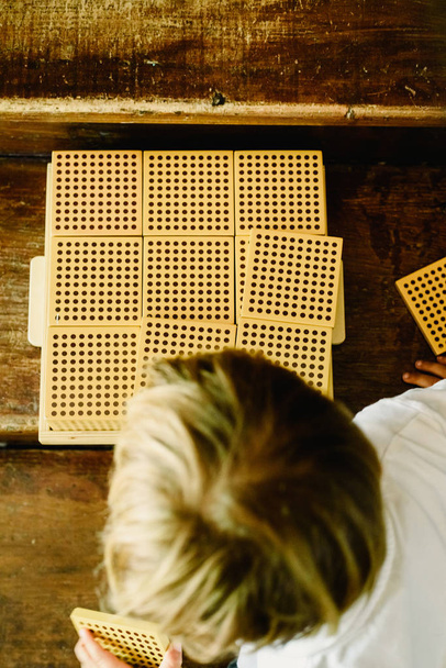 Mãos de menino manipulando cubos de contagem em fundo de madeira em
 - Foto, Imagem