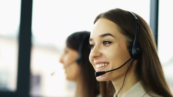 4k. Office Call Center werk. Twee jonge glimlachende vrouwen exploitanten antwoord client  - Video