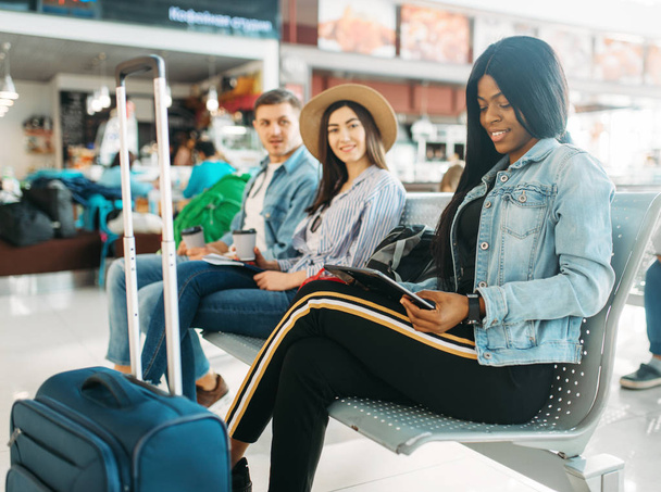 Bavulu olan kadın siyah turist havaalanında niçin yola çıkma bekliyor. Bagajlı yolcular, hava terminalinde uçuşu dört gözle bekliyor, mutlu yolculuklar - Fotoğraf, Görsel