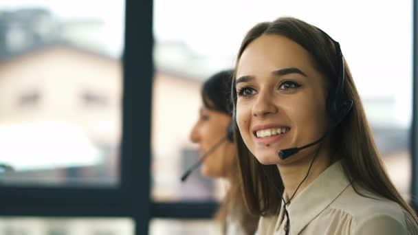 4K. Dos jóvenes operadoras sonrientes responden al cliente. Proceso de trabajo del centro de llamadas
.   - Imágenes, Vídeo