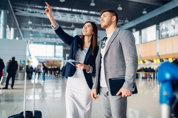 Two passengers of business class waiting in airport, working trip. Businessman and businesswoman in air terminal, negotiation travel - Photo, Image