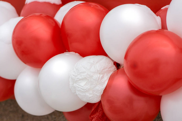 wśród wielu czerwonych i białych balonów jeden przebicia - Zdjęcie, obraz