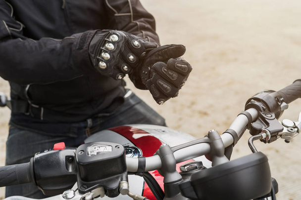 Biker with jacket wearing protect glove and riding motorbike - Foto, Imagem