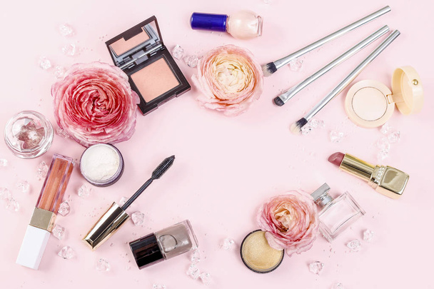 Cosmetics and flowers on pink background. - Фото, изображение