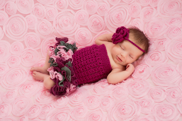 Dormire neonato ragazza indossa una fascia all'uncinetto marrone e pagliaccetto
 - Foto, immagini