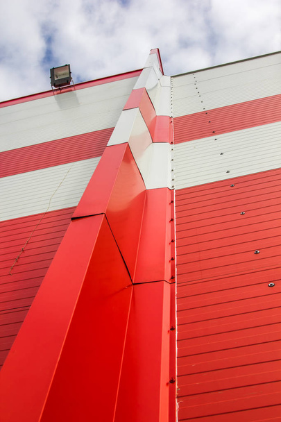 The texture of the wall of the building, made of red and white sandwich panels. Visible structure of the seam between the panels. - Foto, Imagem
