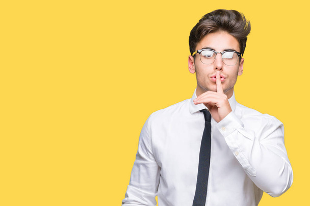Mladí obchodní muž nosí brýle izolované pozadí chce být potichu s prstem na rtech. Mlčení a tajné koncept. - Fotografie, Obrázek