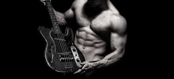 Chest muscles, Six pack, ab, triceps. Music festival. Instrument on stage and band. Strong, muscular, muscles man, bodybuilding. Guitar. Torso man. Play the guitar. Music concept. Electric guitar - Photo, Image