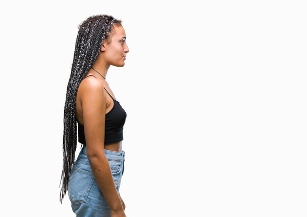 Afroamerykanin młodych splecione włosy z znak urodzenia skazy pigmentacji na białym tle patrząc w bok, zrelaksować się poza profil z naturalną twarz uśmiech i pewność siebie. - Zdjęcie, obraz