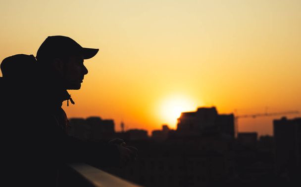 Silhouette of dreaming man in city sunset - Foto, Bild