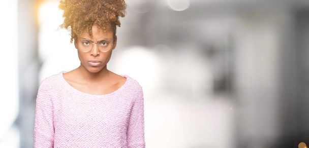 Beautiful young african american woman wearing glasses over isolated background skeptic and nervous, frowning upset because of problem. Negative person. - Photo, Image