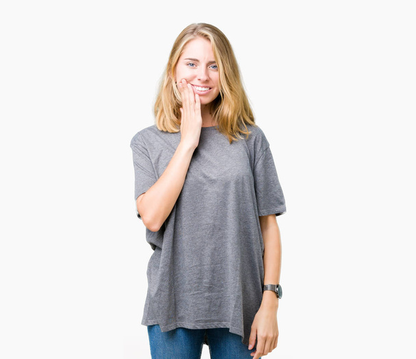 Kaunis nuori nainen yllään ylisuuret rento t-paita yli eristetty tausta koskettaa suuta käsin kivulias ilme, koska hammassärky tai hampaiden sairaus hampaita. Hammaslääkärin käsite
. - Valokuva, kuva