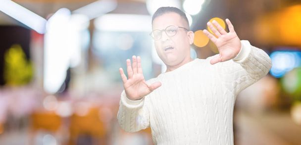 Middle age arab man wearing glasses over isolated background Smiling doing frame using hands palms and fingers, camera perspective - Foto, immagini