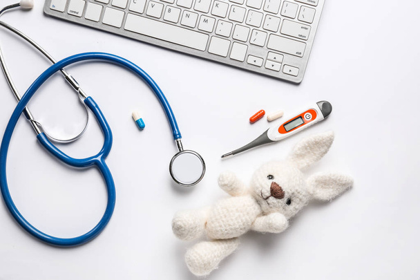 Tastiera per PC, stetoscopio, termometro e giocattolo su sfondo bianco
 - Foto, immagini