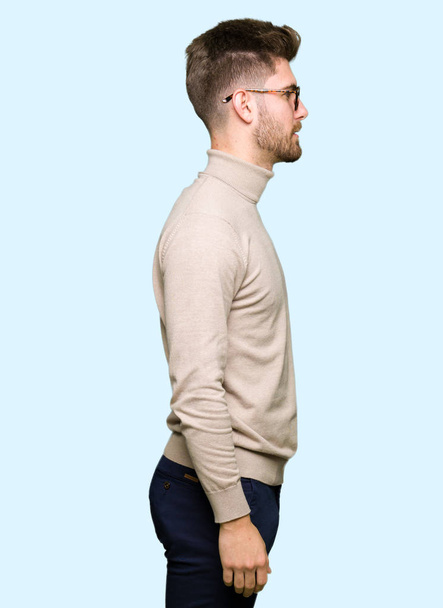 Mladý pohledný obchodní muž nosíš brýle při pohledu na stranu, uvolnit profilu pozice s přirozenou tvář s sebejistý úsměv. - Fotografie, Obrázek