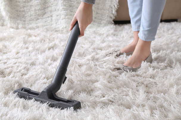 Woman hoovering carpet with vacuum cleaner - Foto, Imagem