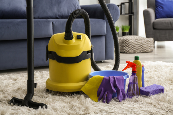 Sprzątanie z odkurzacz na miękkim dywanie w pokoju - Zdjęcie, obraz