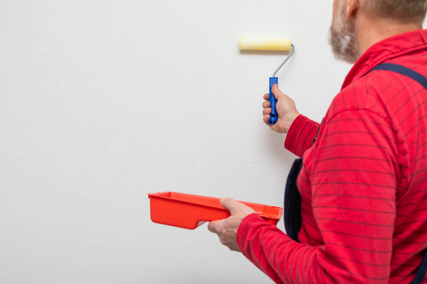 Senior worker painting the walls - Zdjęcie, obraz