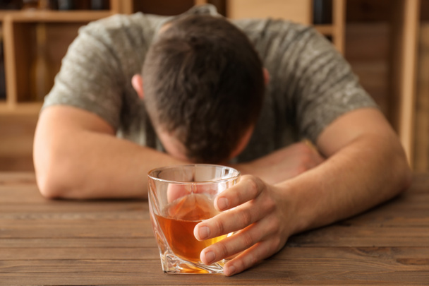 Μεθυσμένος άνθρωπος με ουίσκι στο τραπέζι στο μπαρ - Φωτογραφία, εικόνα