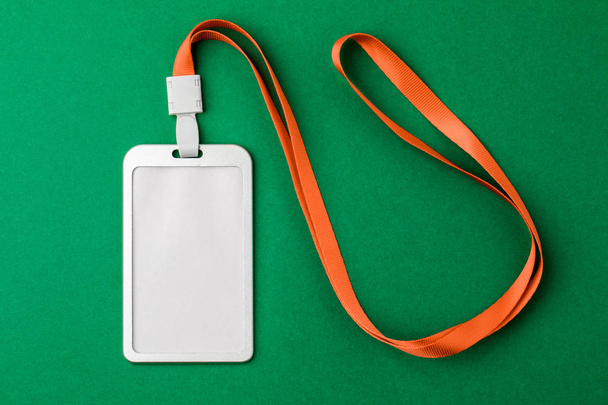 Blank security tag with a red stripe neck on a green background. - Photo, Image