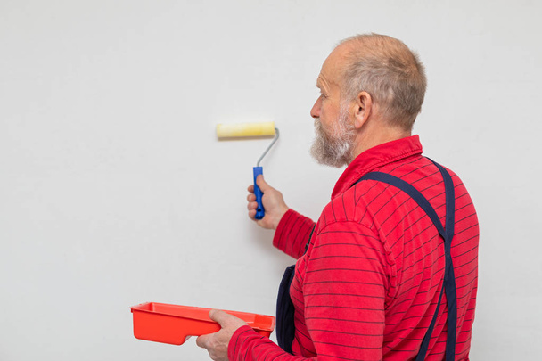 Senior worker painting the walls - Zdjęcie, obraz