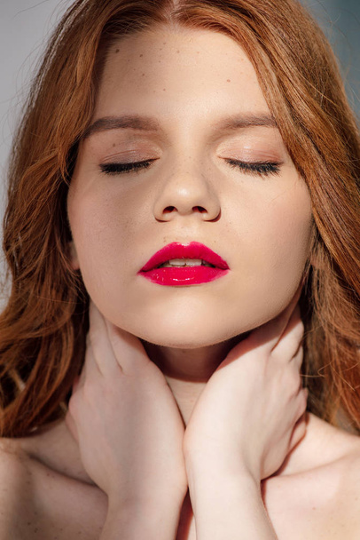beautiful young seductive redhead woman with red lips posing with eyes closed - Foto, Bild