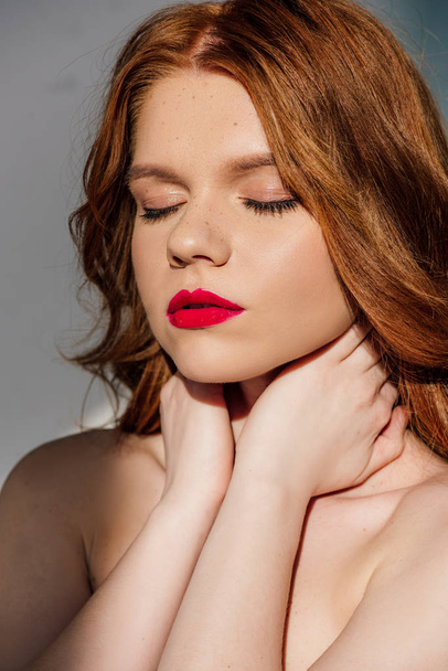 beautiful young seductive redhead woman with red lips posing with eyes closed - Φωτογραφία, εικόνα