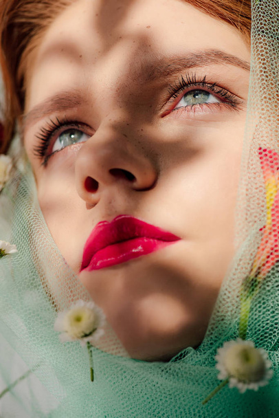 beautiful young woman with red lips covered in veil with flowers - Fotó, kép