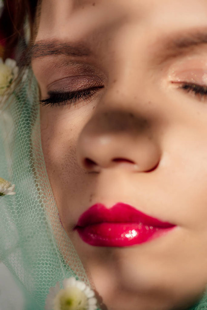 vista de cerca de la hermosa joven con los ojos cerrados y los labios rojos cubiertos de velo con flores
 - Foto, Imagen