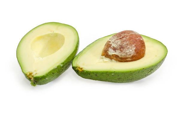 Fruta de abacate verde cortada ao meio em um fundo branco
 - Foto, Imagem