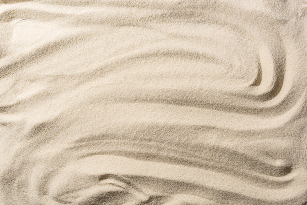 top view of textured sandy beige background with smooth waves - Foto, afbeelding